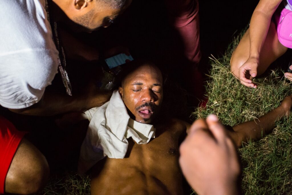 People help a protester who was overcome by tear gas.