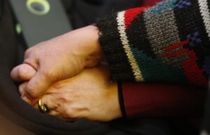 A pair of unidentified women hold hands during prayers in the wake of the Planned Parenthood shooting. 