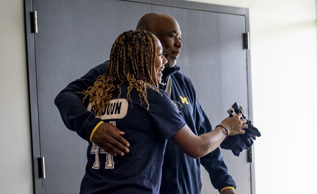Jaedan Brown and her father Corwin Brown hug as attendees arrive for a fundraiser on behalf of the Concussion Legacy Foundation at Wolverine Pickleball in Ann Arbor, Michigan on April 12, 2025. (Photo by Emily Elconin for The Washington Post)