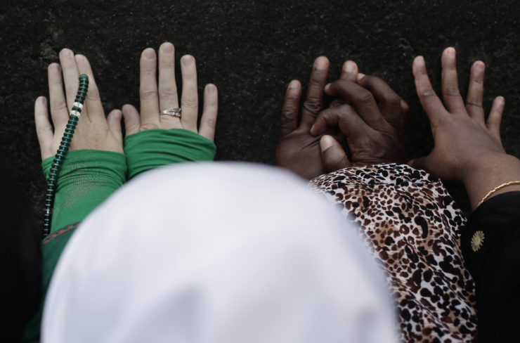 Women touch the Kaaba, Islam's holiest shrine, for blessing at the Grand Mosque in Makkah at the Hajj annual pilgrimage.