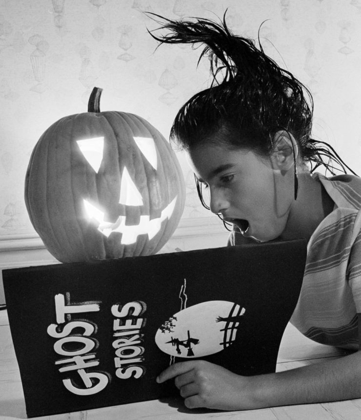 An unidentified girl reads a hair-raising story on a pre-Halloween night in 1964.  