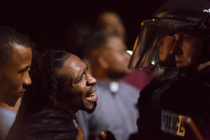 A protester confronts a police officer.