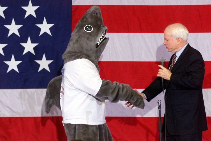 John McCain shakes the fin of "Sharkman," a spokesman for "Citizens for a Sound Economy," after the presidential candidate invited him onstage during a town hall meeting in New Hampshire in January 2000.