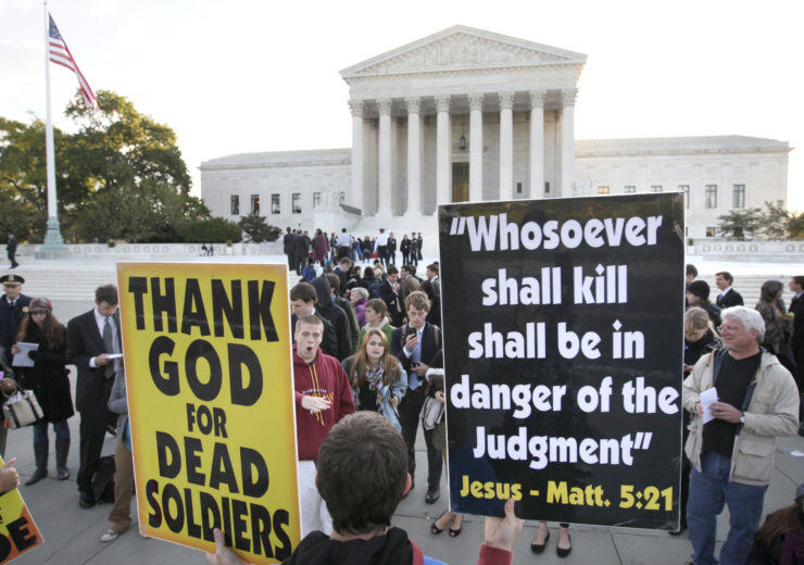 In this 2010 picture, Westboro Baptist Church member Jacob Phelps holds signs in front of the Supreme Court in Washington as the court heard arguments in the dispute between Albert Snyder and members of the church. 