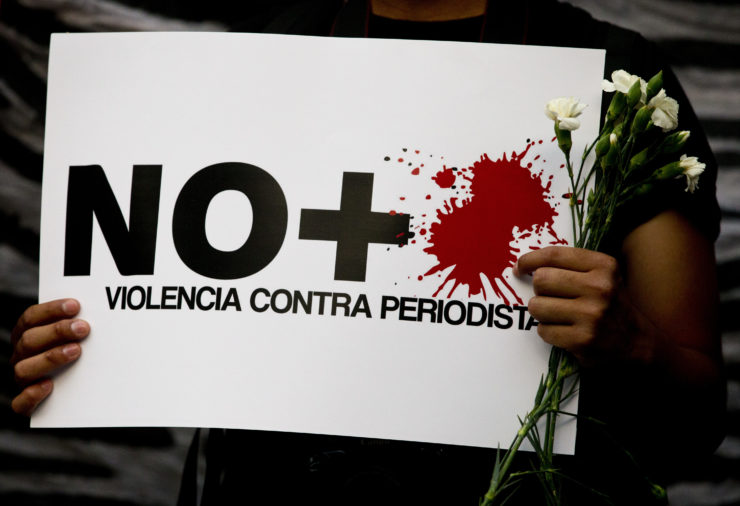 A protestor holds a sign reading "No more violence against journalists," during a demonstration in Mexico City a day after journalist Javier Valdez was slain in the northern state of Sinaloa. 