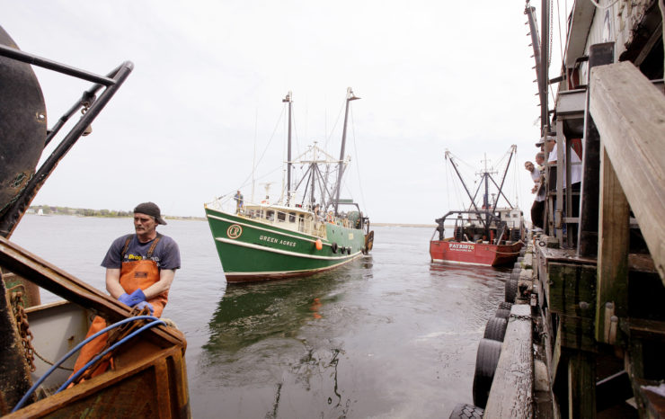 As one fishing vessel leaves the dock another pulls up to offload its catch in New Bedford, Mass.