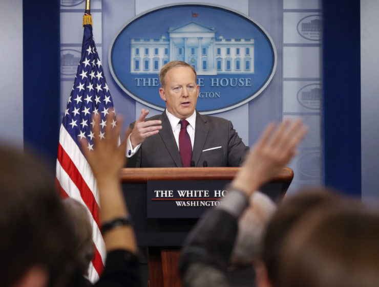 Members of the media raise their hands as White House Press secretary Sean Spicer answers questions. 