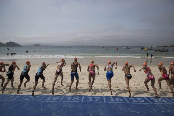Competitors run to the water for the start of the women's triathlon event at the 2016 Summer Olympics in Rio de Janeiro.