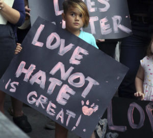A child at an anti-racism rally called to denounce the messages of hate and violence of white supremacists at a weekend rally in Charlottesville, Virginia.