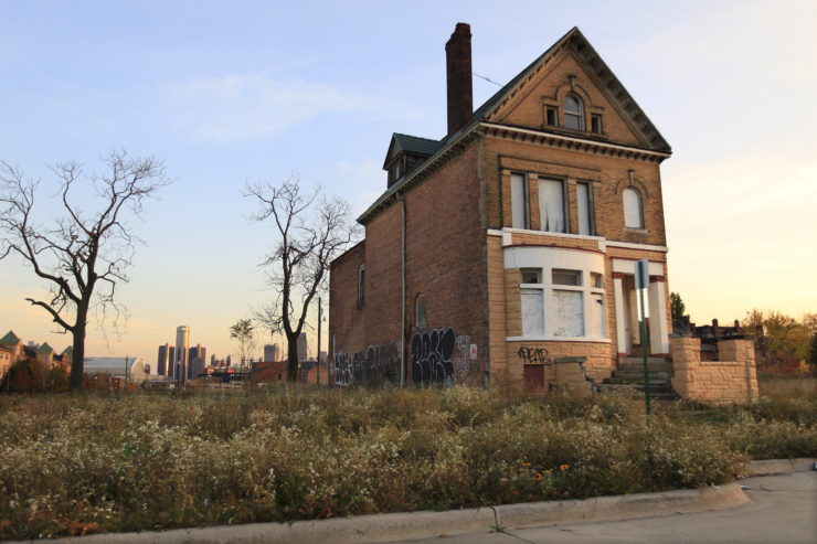 A graffiti-marked abandoned home north of downtown Detroit, in background. 