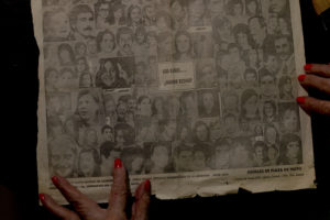 Delia Giovanola, holds a newspaper with pictures of disappeared during Argentina's dictatorship, reading in Spanish, "Where are their babies."