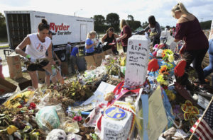 Volunteers, students and parents sort items left at the memorial site for the 17 students and faculty killed at Marjory Stoneman Douglas High School in Parkland, Fla.
