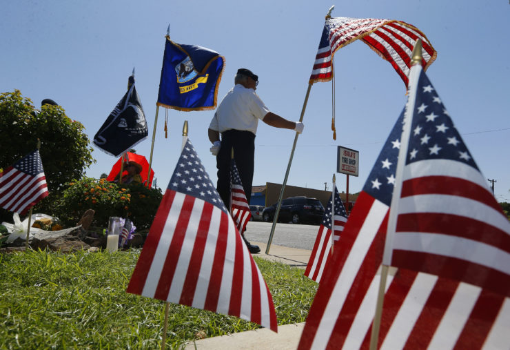 Flags frame David Carrasco, a member of the POW-MIA-KIA Honor Guard, as he stands watch in honor of the late Arizona Republican Sen. John McCain at a local mortuary where McCain is being kept Monday, Aug. 27, 2018, in Phoenix. McCain, the war hero who became the GOP's standard-bearer in the 2008 election, died at the age of 81, Saturday, Aug. 25, 2018, after battling brain cancer.