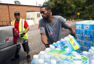 Shawn Jones, right, and Tony Price, distribute bottled water at a church in Flint, Michigan, where the city water system was contaminated with lead.