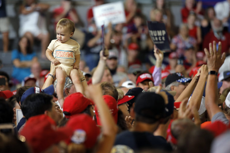 A baby is lifted into the air as President Donald Trump speaks at a campaign rally in Greenville, N.C., Wednesday, July 17, 2019.