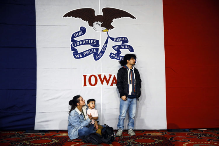 Two people in Iowa watch caucus returns come in.