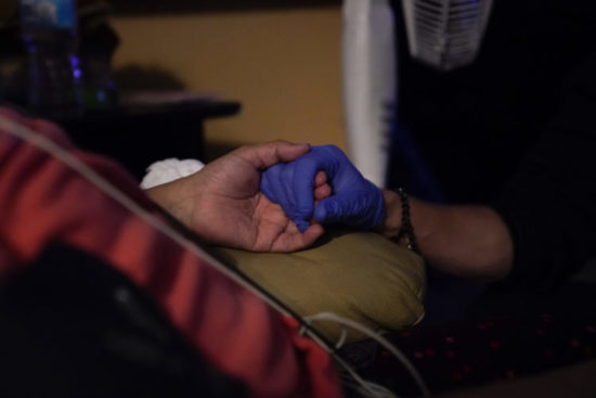 An EMT holds a patient's hand to calm her