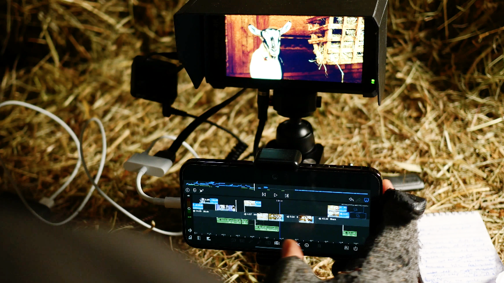 A man edits video footage on his iPhone with a mobile editing station