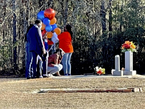 Ahmaud Arbery's mother, Wanda Cooper-Jones, kneels before Arbery's grave in Waynesboro, Georgia