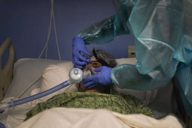 A nurse adjusts the ventilator on her COVID-19 patient at St. Joseph Hospital in Orange, Calif., in this January 2021 photo.