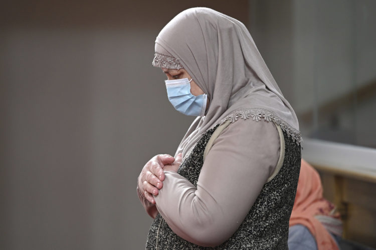 A Muslim woman wearing a COVID mask prays during Ramadan in New York City