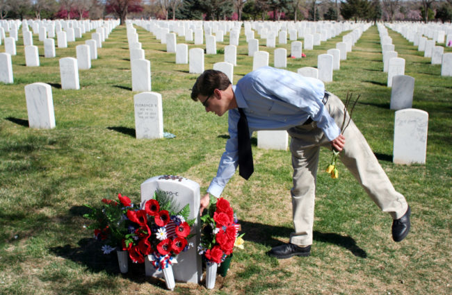 Jim Sheeler places flowers on the grave of a fallen service member at Fort Logan National Cemetery in Denver, Colorodo.