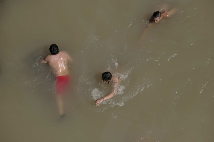People swim in the Sandy River near Portland, Oregon, during record heat in June 2021