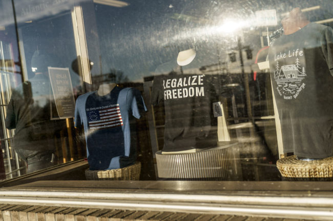 A storefront window in Benson, Minnesota, that displays T-shirts with conservative political slogans.