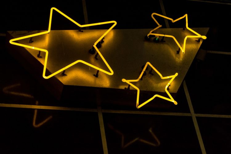 Three gold neon stars on a wall