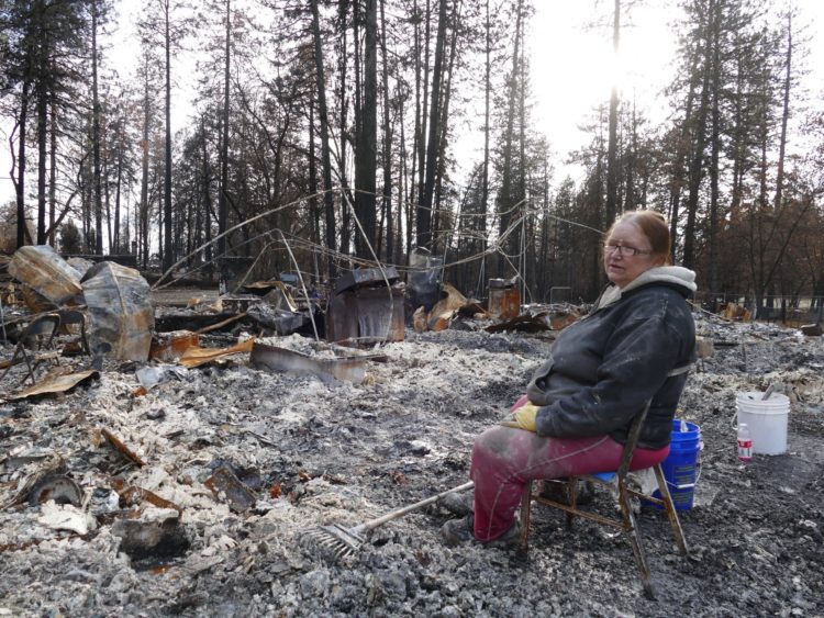 A woman in front of the ruins of her home destroyed in the 2018 Camp Fire in Paradise, California