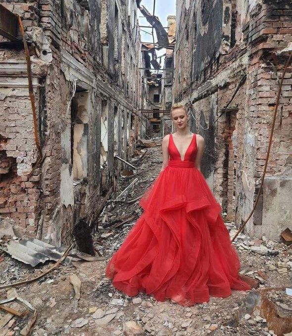 Image of a high school graduate in a red gown in the rubble of Kharkiv, Ukraine