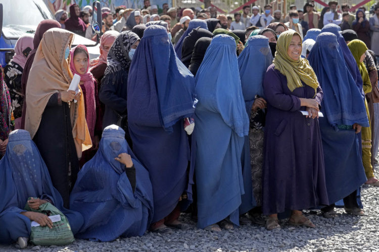 Afghan women wait to receive food rations distributed by a humanitarian aid group, in Kabul, Afghanistan, in April 25, 2022. Women were ordered to wear full burqas in public after the Taliban retook control of the country following the 2021 pullout of U.S. troops.