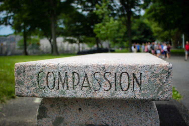 A tone bench etched with the word COMPASSION