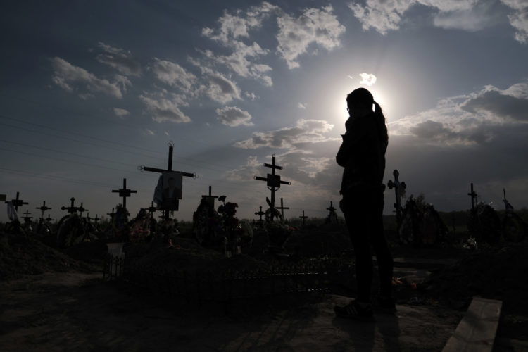 A woman grieves at her husband's grave in Bucha, Kyiv, which was the site of a massacre of civilians by Russian soldiers