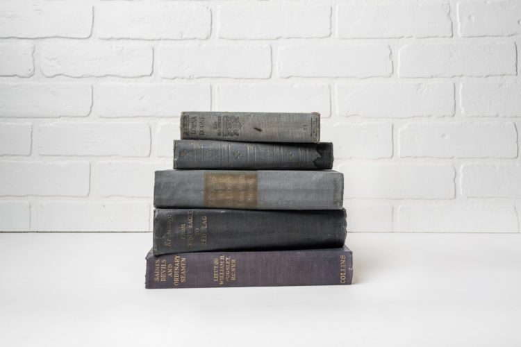 A small stack of classic novels on a white table