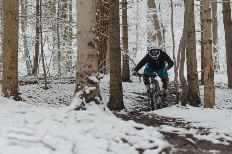 Photo of a mountain biker on a forested trail in winter