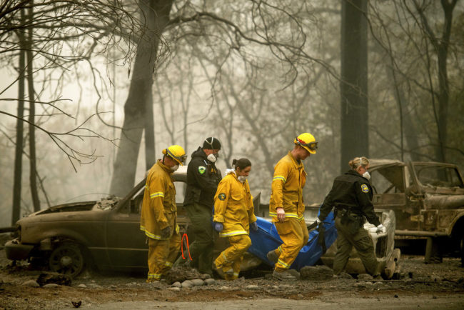 Firefighters carrying a body out of the Camp Fire that destroyed much of Paradise, California, in November 2018.