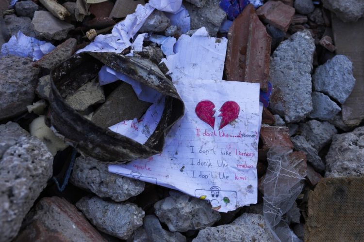 Photo of a child's schoolwork page drawn with a heart on the top in the rubble of the earthquake in Turkey