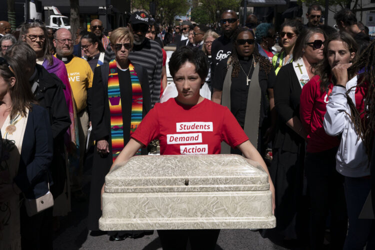 A student in Tennessee holds a child's casket during a rally to protest gun violence.