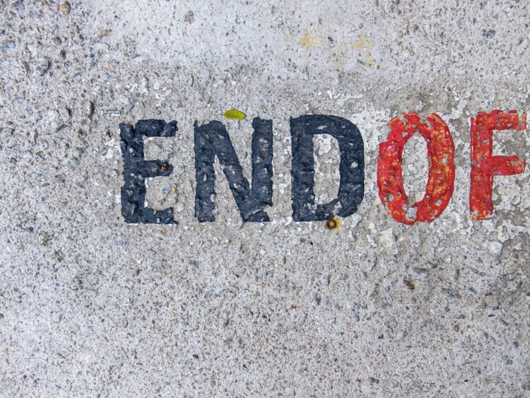 Photo of a sidewalk with words END OF.