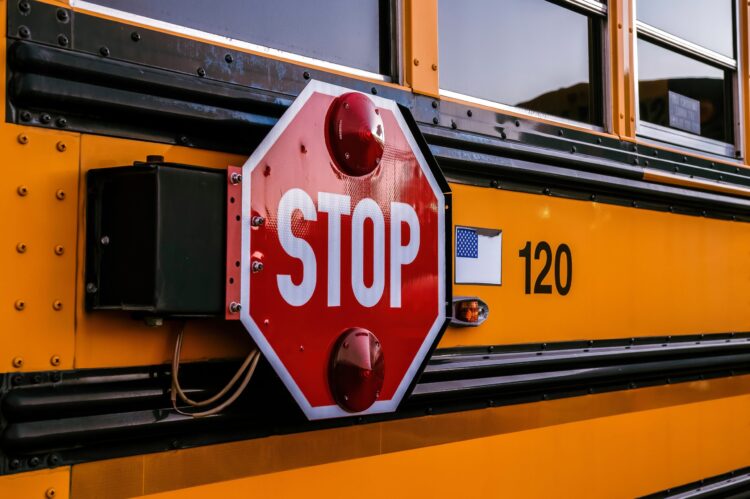 Side of a school bus with a STOP sign attached