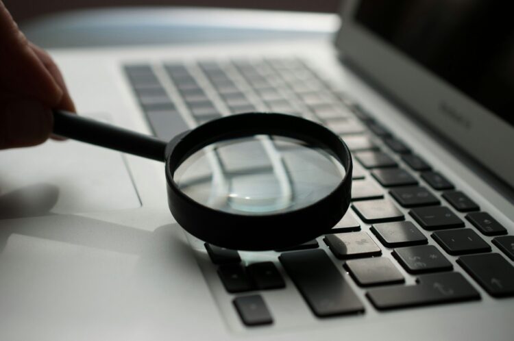 Photo of a magnifying glass on a laptop computer keyboard