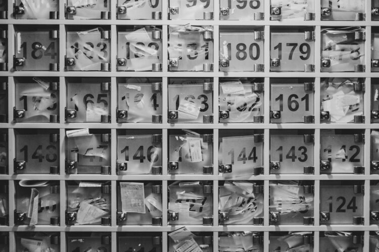 Black-and-white photo of multiple mail slots.