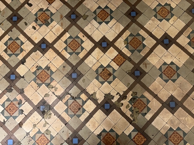 Close-up shot of the chipped tile floor in the main room of the Hong Kong Foreign Correspondents' Club.