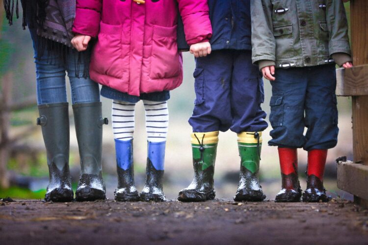 Photo of four children in rain gear and boots