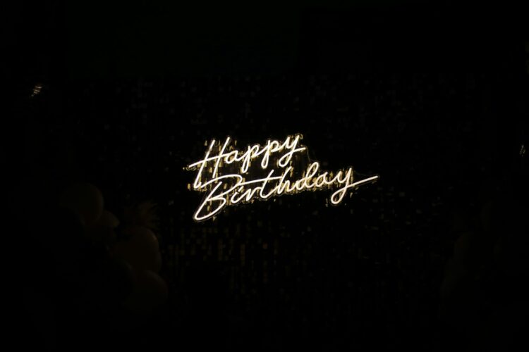 White neon script on a black background that reads "Happy Birthday"